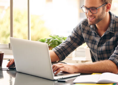 ein Mann sitzt an einem Tisch mit einem Laptop